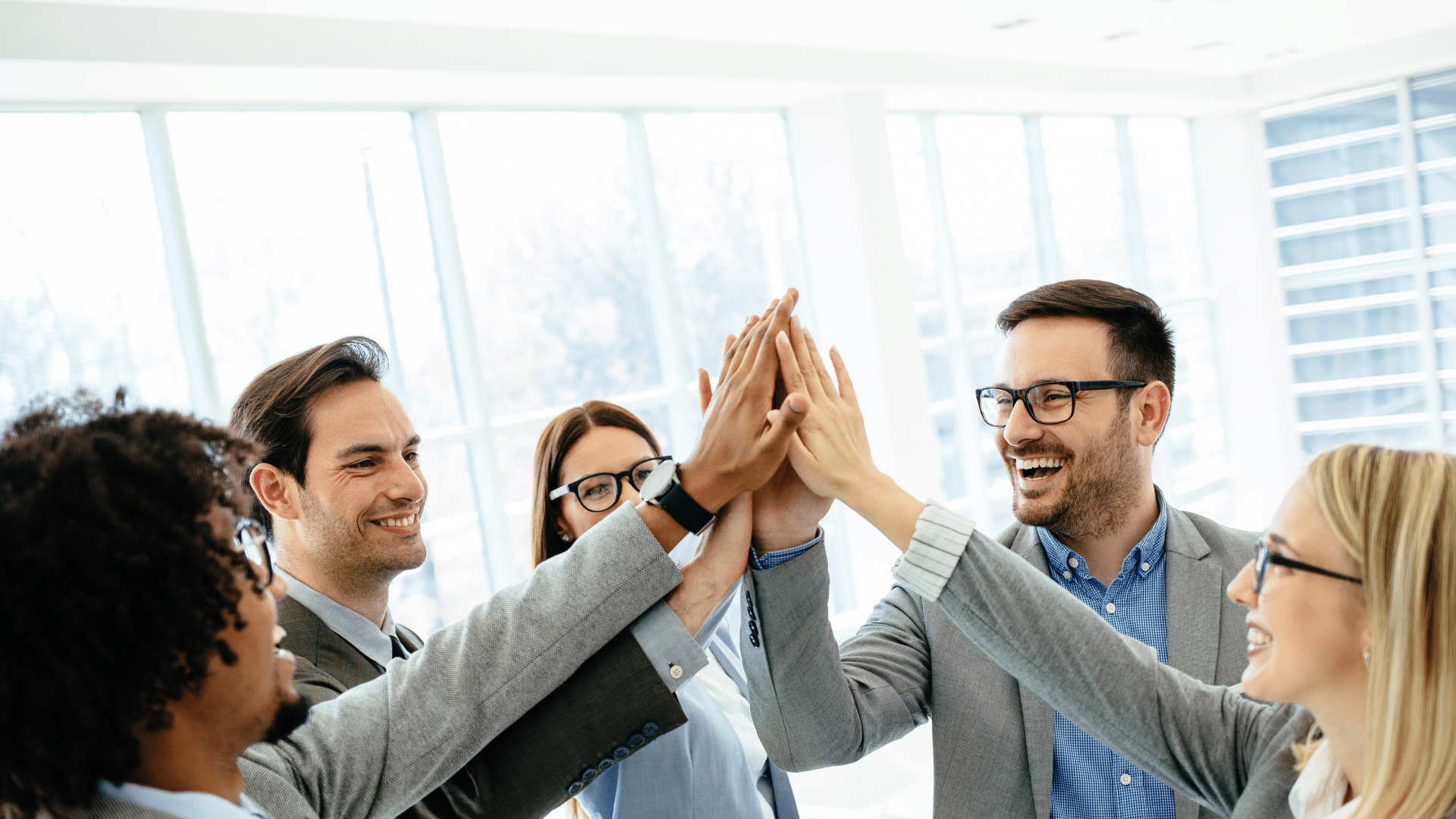 Ein Team gibt sich ein High Five – ein Zeichen für Zusammenhalt, Motivation und Erfolg im Beruf.