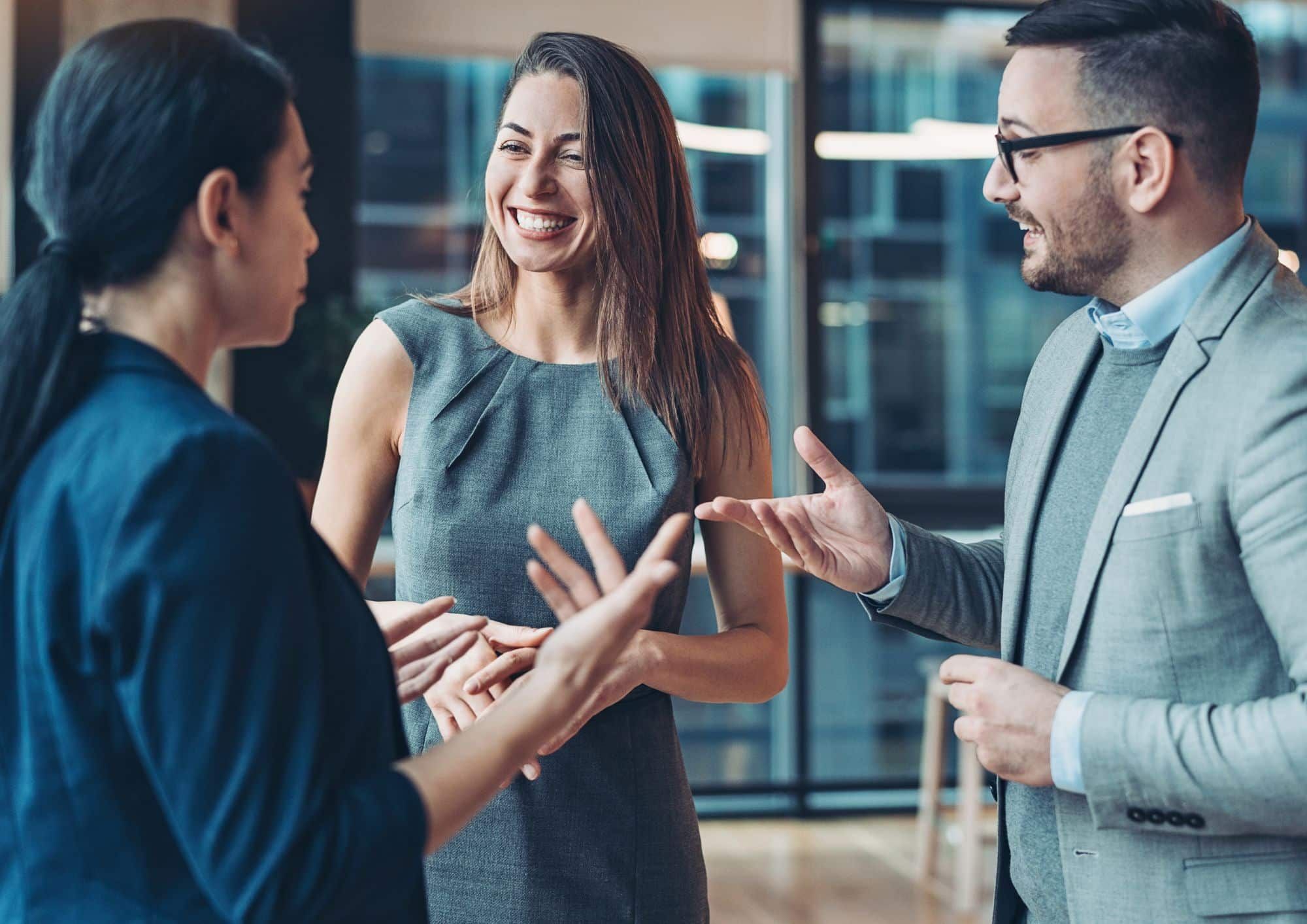 Drei Personen bei einem Verkaufsgespräch während einer Verkaufstraining-Veranstaltung in Bonn, die sich auf Verkaufsstrategien und Networking konzentrieren.
