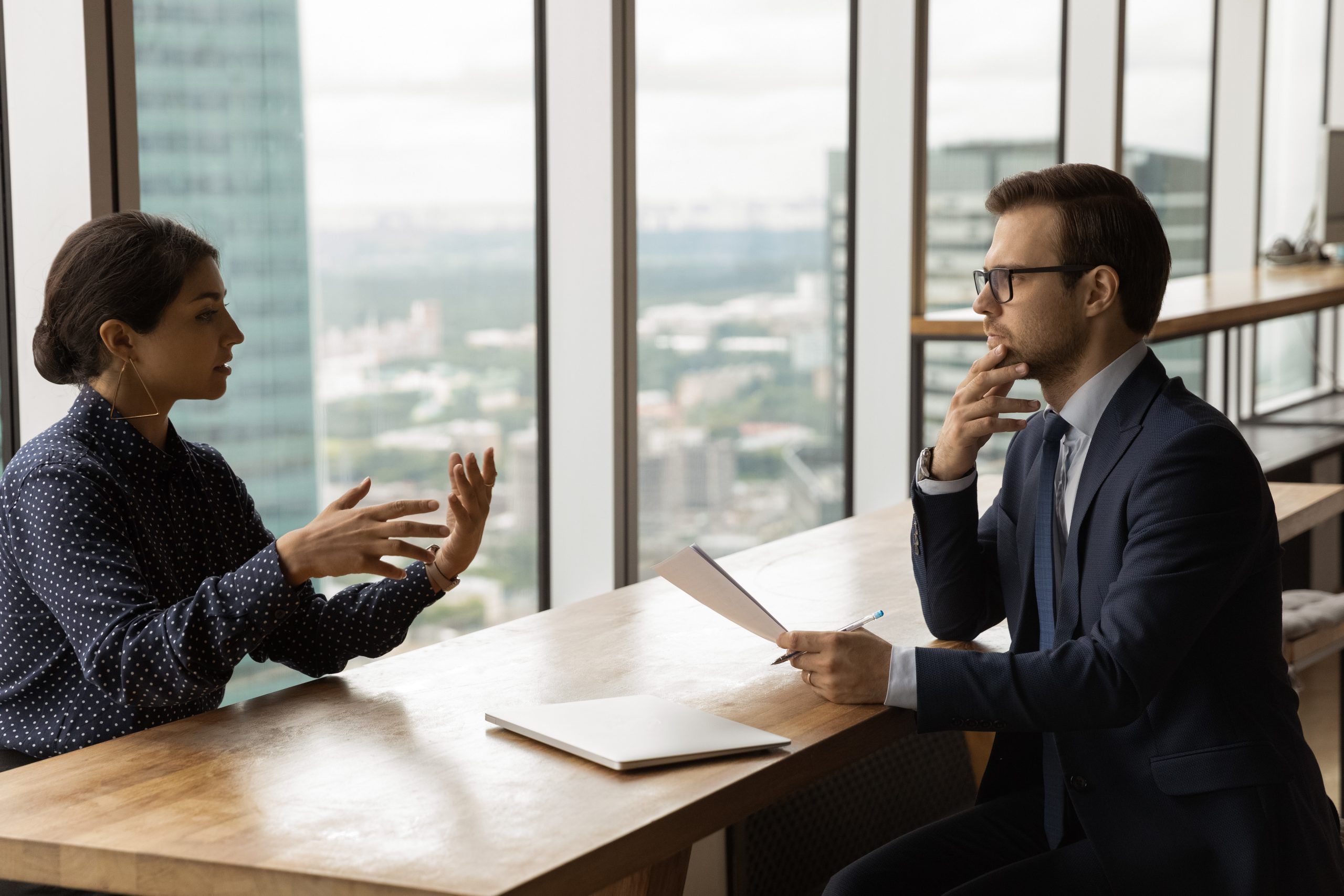 Zwei Geschäftspersonen im Gespräch während eines Meetings – Körpersprache, Gestik und Mimik im Einsatz zur nonverbalen Kommunikation