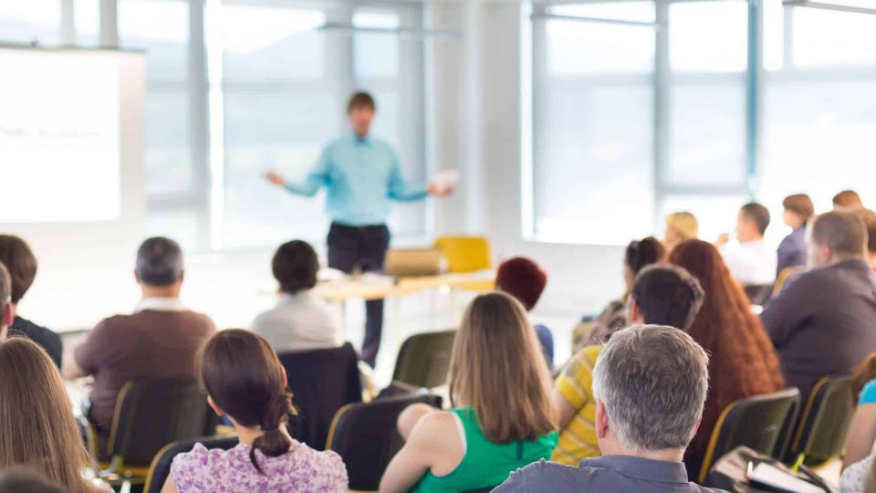 Verkaufstraining im Schulungsraum: Teilnehmer lernen effektive Verkaufstechniken und Strategien von einem Trainer in einer professionellen Lernumgebung.