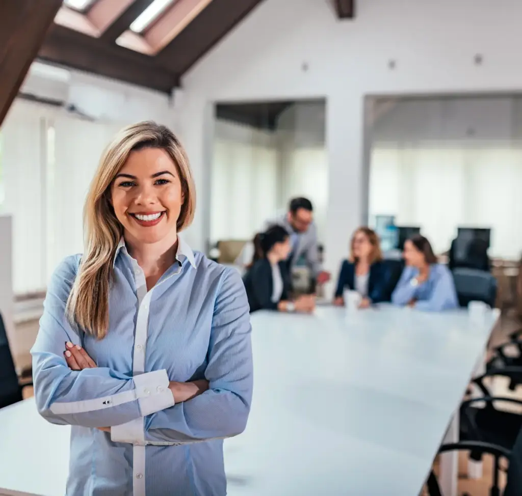Seminar für Außendienstmitarbeiter mit Fokus auf Effizienzsteigerung im Außendienst – erfolgreiche Geschäftsfrau im modernen Meetingraum vor Team