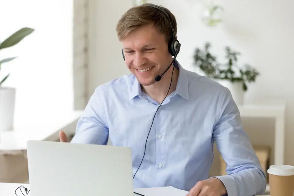 Mitarbeiter mit Headset sitzt vor dem Computer und führt ein professionelles Telefonakquise-Gespräch.