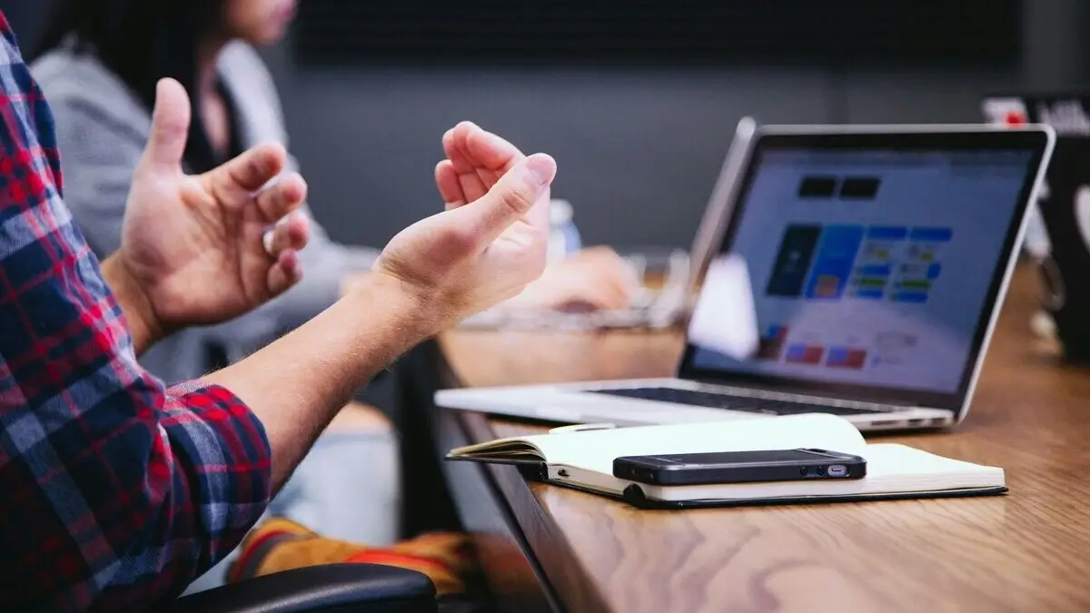 Gestikulierende Hände als Verhandlungssymbol neben PDF-Download