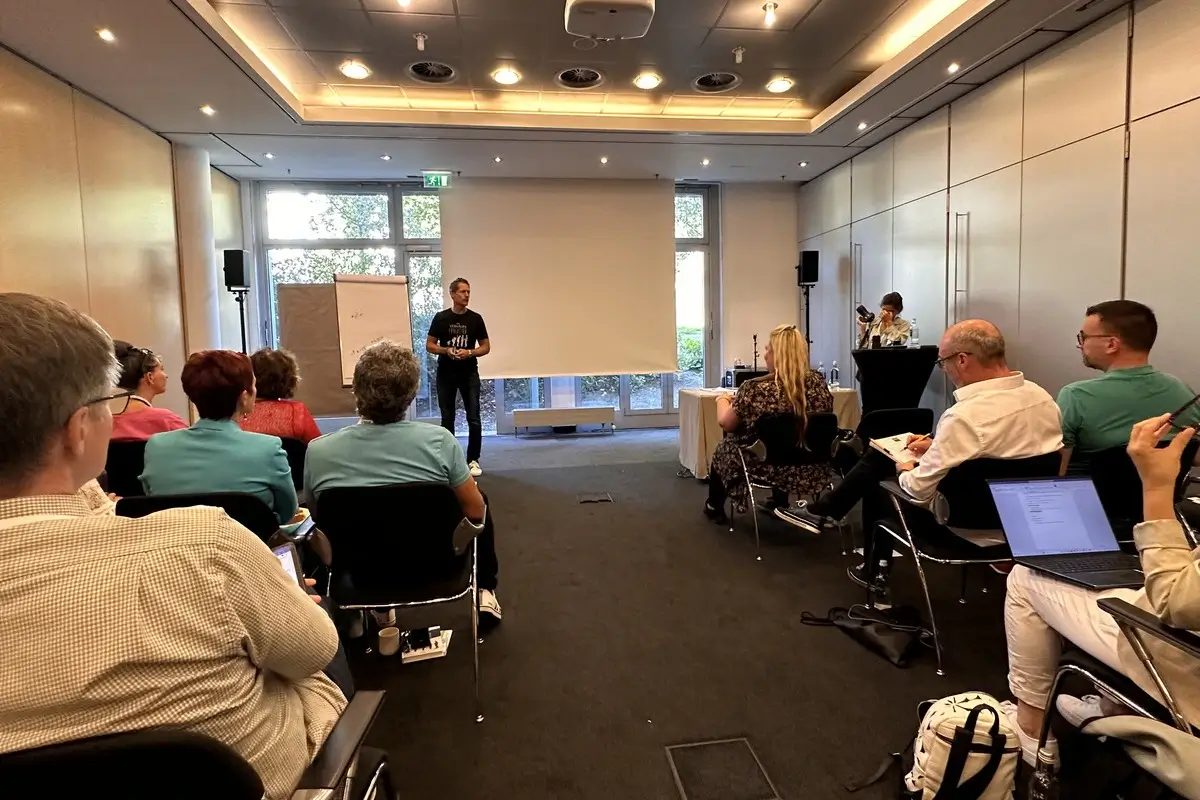 Dirk Stöcker hält einen Vortrag über Persönlichkeitsentwicklung, während die Teilnehmenden aufmerksam zuhören und sich Notizen machen.