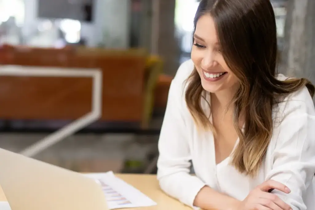 Blended Learning mit Präsenz und Online Lernen dargestellt durch eine Mitarbeiterin am Laptop