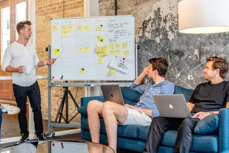 Führungskraft und Mitarbeiter sitzen sich in einem modernen Büro gegenüber und führen ein strukturiertes Gespräch – Symbolbild für ein firmeninternes Transfergespräch.