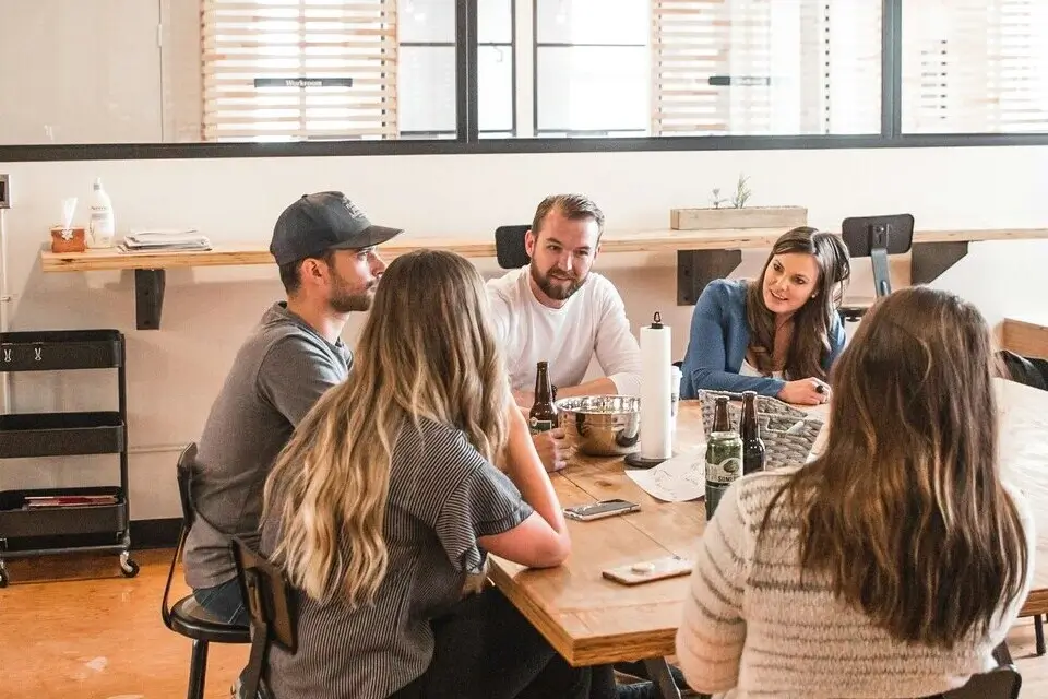 Mitarbeiter sitzen in einem Besprechungsraum zusammen und besprechen nachhaltige Vertriebsschulungen